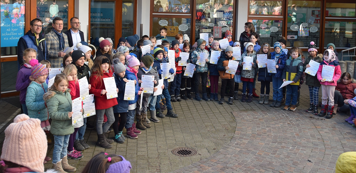 Foto mit Kindern, die eine Volkslauf-Urkunde in den Händen halten